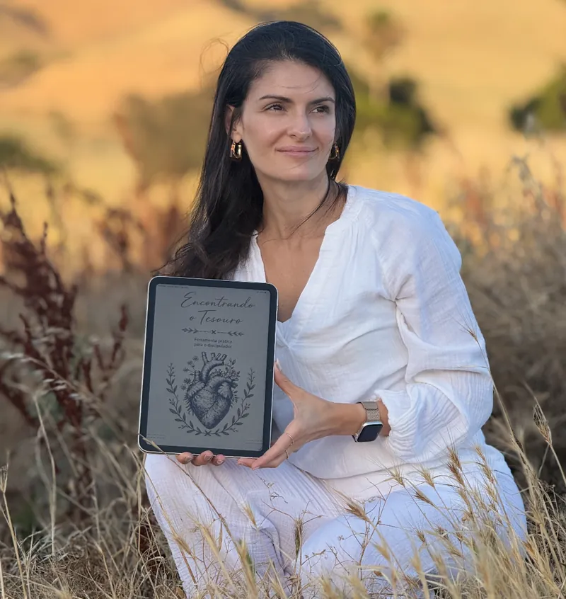 Mulher segurando o iPad com a capa do caderno digital, em um campo