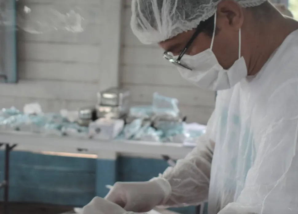 Voluntário preparando material esterilizado para atendimento médico e odontológico